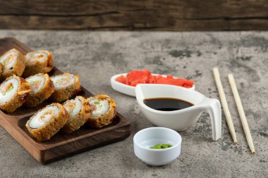 Taş zemine yerleştirilmiş ahşap bir tabak sıcak suşi rulosu. Yüksek kalite fotoğraf