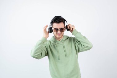 Genç yakışıklı bir adamın beyaza kulaklık takması. Yüksek kalite fotoğraf