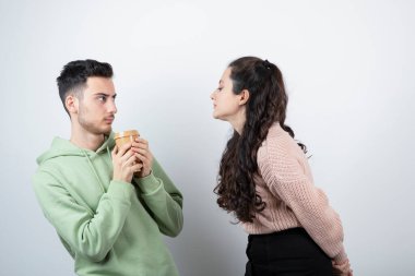 Güzel bir kadın ona bakarken genç bir adam elinde bir fincan kahve tutuyor. Yüksek kalite fotoğraf