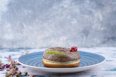 Mavi tabak lezzetli çikolata taze çörek ve kirazlı ve renkli serpiştirilmiş. Yüksek kalite fotoğraf