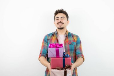 Çekici bir adamın portresi hediye kutularını tutuyor ve kameraya bakıyor. Yüksek kalite fotoğraf