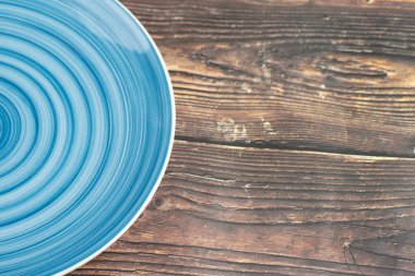Empty blue dinner plate placed on wooden background. High quality photo