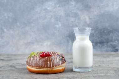 Çikolatalı çörek ve taş yüzeyde bir bardak taze sütle süslenmiş. Yüksek kalite fotoğraf