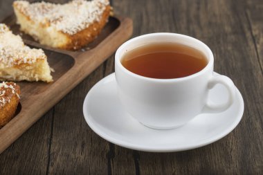 Hindistan cevizi dilimli tatlı dilimleri ve ahşap masaya konmuş bir fincan çay. Yüksek kalite fotoğraf