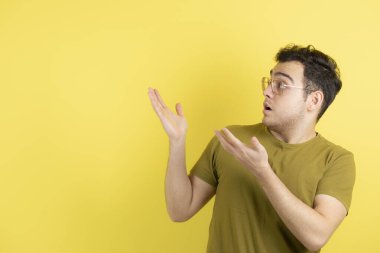 Bir yerlere bakan gözlüklü yakışıklı erkek modelin fotoğrafı. Yüksek kalite fotoğraf