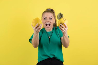 Yeşil bluzlu, olgun bıldırcın tutan genç bir kadının portresi şaşırmış görünüyor. Yüksek kalite fotoğraf