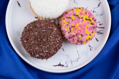 Tabağa renkli şeker serpiştirilmiş üç taze kurabiye. Yüksek kalite fotoğraf