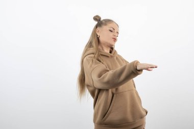 Beyaz duvarın üzerinde duran sarışın kadın modelin portresi. Yüksek kalite fotoğraf