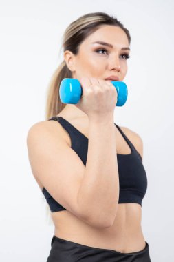 Beyaz arka planda dambılları olan genç bir kadın.