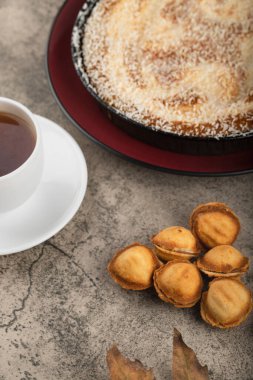 Hindistan cevizli turta, fındık şeklinde kurabiyeler ve arka planda bir fincan sıcak çay. Yüksek kalite fotoğraf