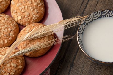 Bir kase sütün yanında tohum ve tahıllı yulaf ezmeli kurabiye. Yüksek kalite fotoğraf