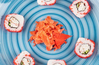 Mavi tabak California suşi ruloları ve turşulu zencefil arka planı. Yüksek kalite fotoğraf