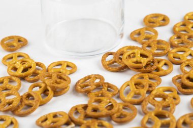 Beyaz zemin üzerine dağılmış lezzetli gevrek krakerler ve bir bardak su. Yüksek kalite fotoğraf