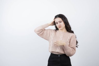 Kafasını beyaz duvara dayamış güzel bir kadın görüntüsü. Yüksek kalite fotoğraf