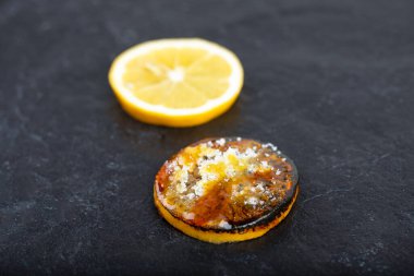 Siyah arka planda taze dilimlenmiş kızarmış limon dilimi. Yüksek kalite fotoğraf