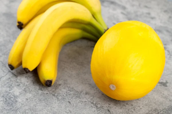 Mazzo Banane Fresche Con Melone Giallo Isolato Fondo Pietra Foto — Foto Stock