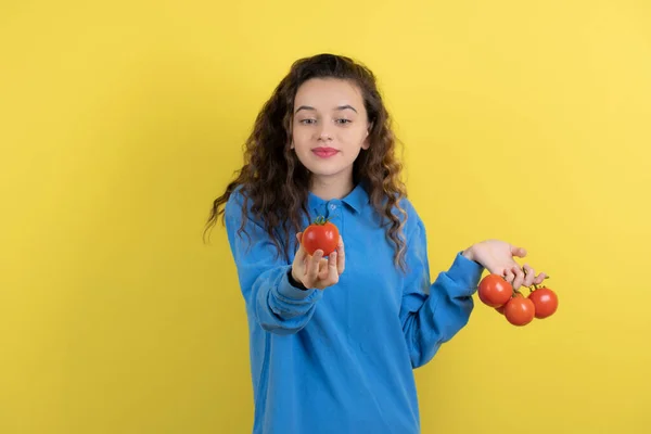 Νεαρή Έφηβη Μπλε Μπλούζα Που Κοιτάζει Μια Κόκκινη Ντομάτα Υψηλής — Φωτογραφία Αρχείου