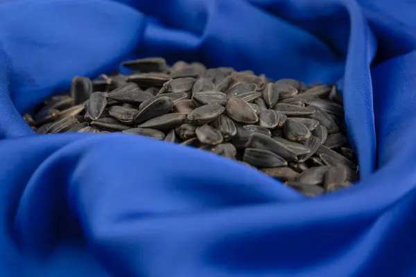Άλμα Γεμάτο Από Ηλιόσπορους Μαύρους Σπόρους Που Τοποθετούνται Μπλε Τραπεζομάντιλο — Φωτογραφία Αρχείου
