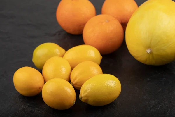 黒の背景に黄色のレモン オレンジ 黄色のメロンの束 高品質の写真 — ストック写真