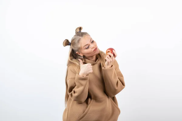 赤いリンゴを持つ美しいブロンドの女性は親指を放棄します 高品質の写真 — ストック写真