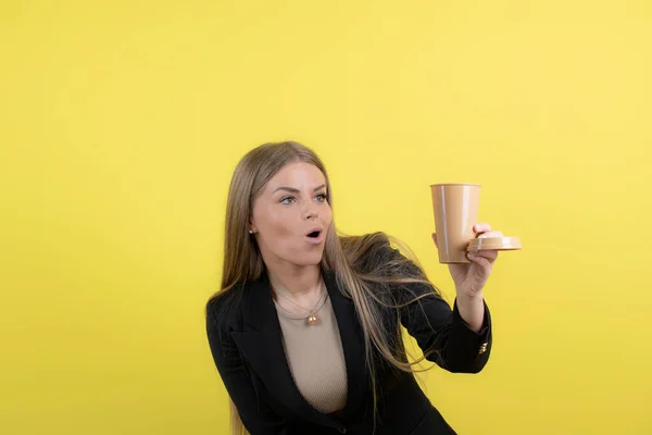 Νεαρή Επιχειρηματίας Ποζάρει Ένα Ποτήρι Ποτό Στον Κίτρινο Τοίχο Υψηλής — Φωτογραφία Αρχείου