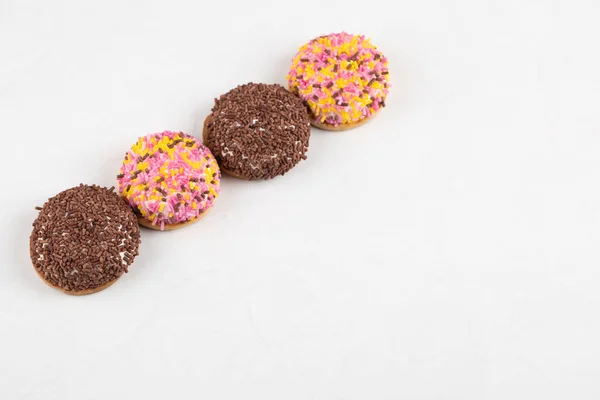 Four Fresh Cookies Colorful Sprinkles Placed White Background High Quality — Φωτογραφία Αρχείου