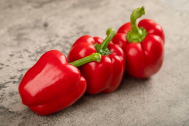 Taş zeminde üç tane parlak kırmızı dolma biber. Yüksek kalite fotoğraf