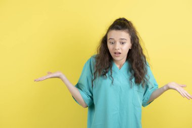 Sarı arka planda poz veren kıvırcık kadın hemşire. Yüksek kalite fotoğraf