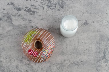 Çikolatalı çörek ve taş yüzeyde bir bardak taze sütle süslenmiş. Yüksek kalite fotoğraf