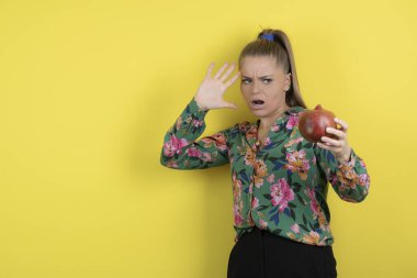 Sarı arka planda nar tutan genç bir kadının portresi. Yüksek kalite fotoğraf