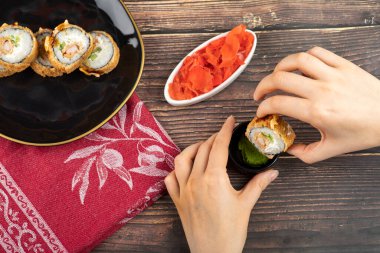 Kadın eli, soya sosuna sıcak suşi koyar. Yüksek kalite fotoğraf