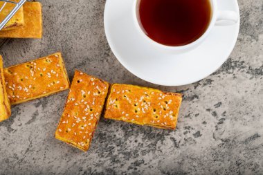 Susam tohumlu tatlı krakerler ve taş masaya konmuş bir fincan çay. Yüksek kalite fotoğraf