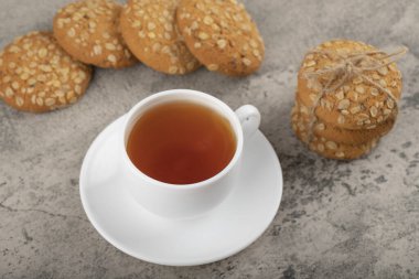 Bir fincan siyah çay ve tahıl gevreği ve tohumlu yulaf ezmeli kurabiyeler. Yüksek kalite fotoğraf