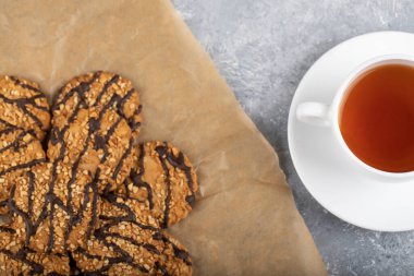 Çikolata kaplı yulaflı kurabiyeler ve bir fincan çay. Yüksek kalite fotoğraf