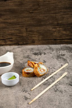 Sıcak suşi ruloları, soya sosu ve taş yüzeyde wasabi. Yüksek kalite fotoğraf