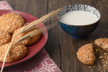 Yulaf ezmeli bisküvi ve ahşap masada bir kase taze süt. Yüksek kalite fotoğraf