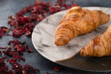 Güzel bir tabağa yerleştirilmiş lezzetli tereyağlı kruvasanlar. Yüksek kalite fotoğraf