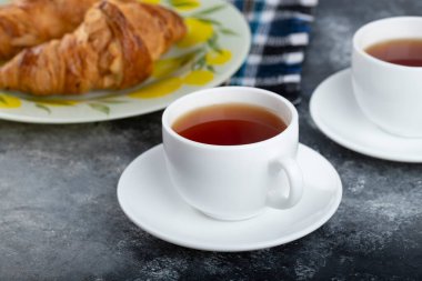 Tereyağlı kruvasan ve bir fincan çay. Yüksek kalite fotoğraf