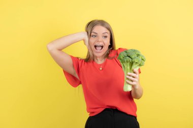 Büyük yeşil brokoli tutan güzel bir kadın modeli resmi. Yüksek kalite fotoğraf