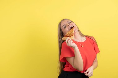 Lezzetli bir dilim pizza yiyen çekici bir kadın görüntüsü. Yüksek kalite fotoğraf