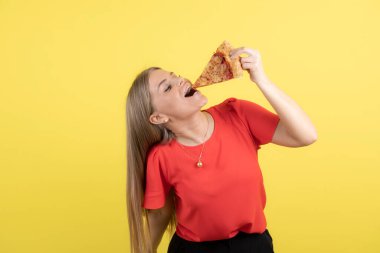 Lezzetli bir dilim pizza yiyen çekici bir kadın görüntüsü. Yüksek kalite fotoğraf