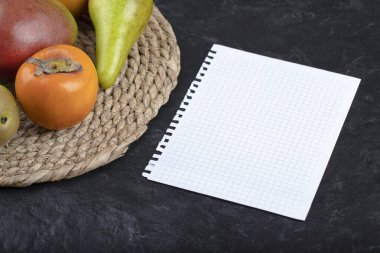 Lezzetli taze olgun meyveler ve siyah arka planda boş kağıt. Yüksek kalite fotoğraf