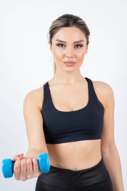 Beyaz arka planda dambılları olan genç bir kadın.