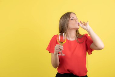 Güzel bir kadının elinde şarap kadehiyle ayakta durduğu bir fotoğraf. Yüksek kalite fotoğraf