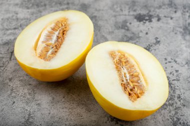 Taş zemine yarım dilimlenmiş sarı kavun yerleştirilmiş. Yüksek kalite fotoğraf