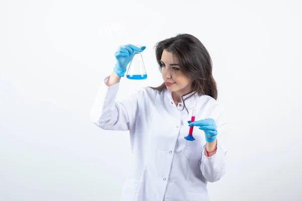 研究室でフラスコを見ている若い女性化学研究者 高品質の写真 — ストック写真