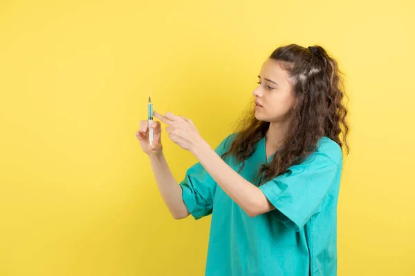 Image Une Jeune Infirmière Uniforme Tenant Soigneusement Seringue Contre Mur — Photo