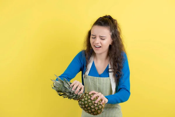 Młody Kręcony Nastolatek Fartuchu Trzymający Dojrzały Ananas Żółtej Ścianie Wysokiej — Zdjęcie stockowe