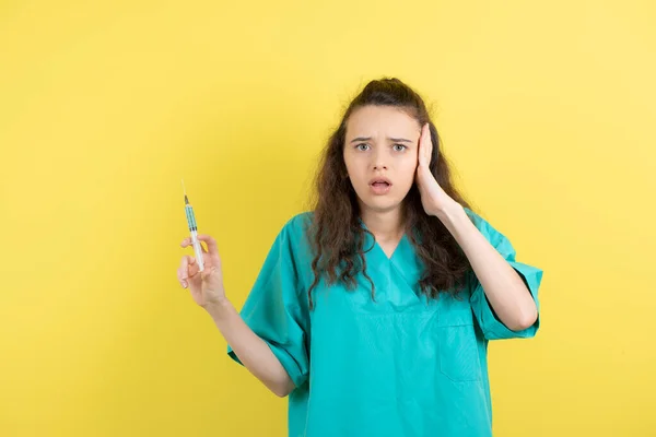 Imagem Uma Enfermeira Adolescente Segurando Seringa Fundo Amarelo Foto Alta — Fotografia de Stock