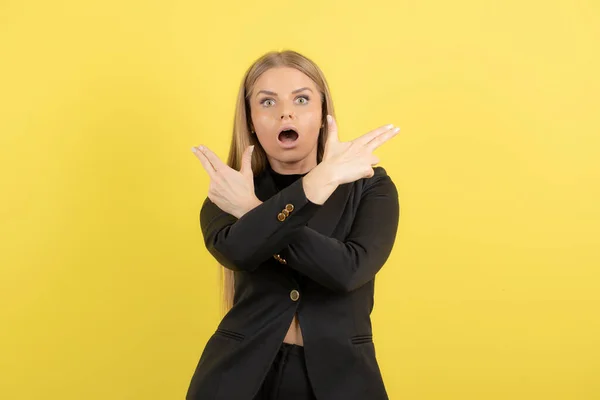 Junge Frau Schwarzen Anzug Steht Und Zeigt Auf Gelben Hintergrund — Stockfoto